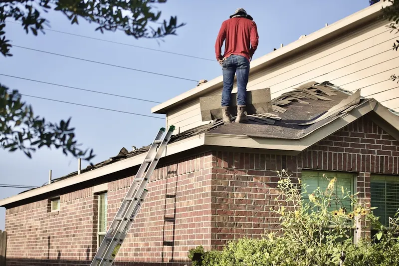 Professional roofer working on a residential roof in Middle Village